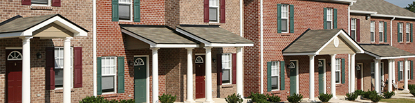 The exterior of a row of house fronts made of brick.