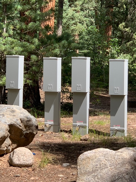 A close-up on four Milbank pedestals used to distribute power at an RV park.