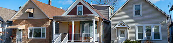 The front of three houses standing next to each other.