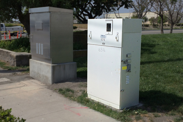 A Milbank enclosed control standing next to a traffic control cabinet.