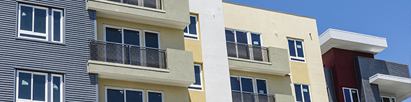 Partial shot of the exterior of an apartment building colored blue and yellow.
