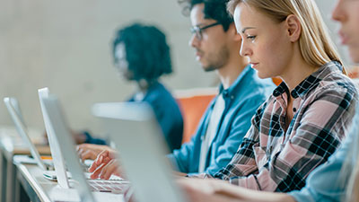 A row of adults sitting while working on computers.