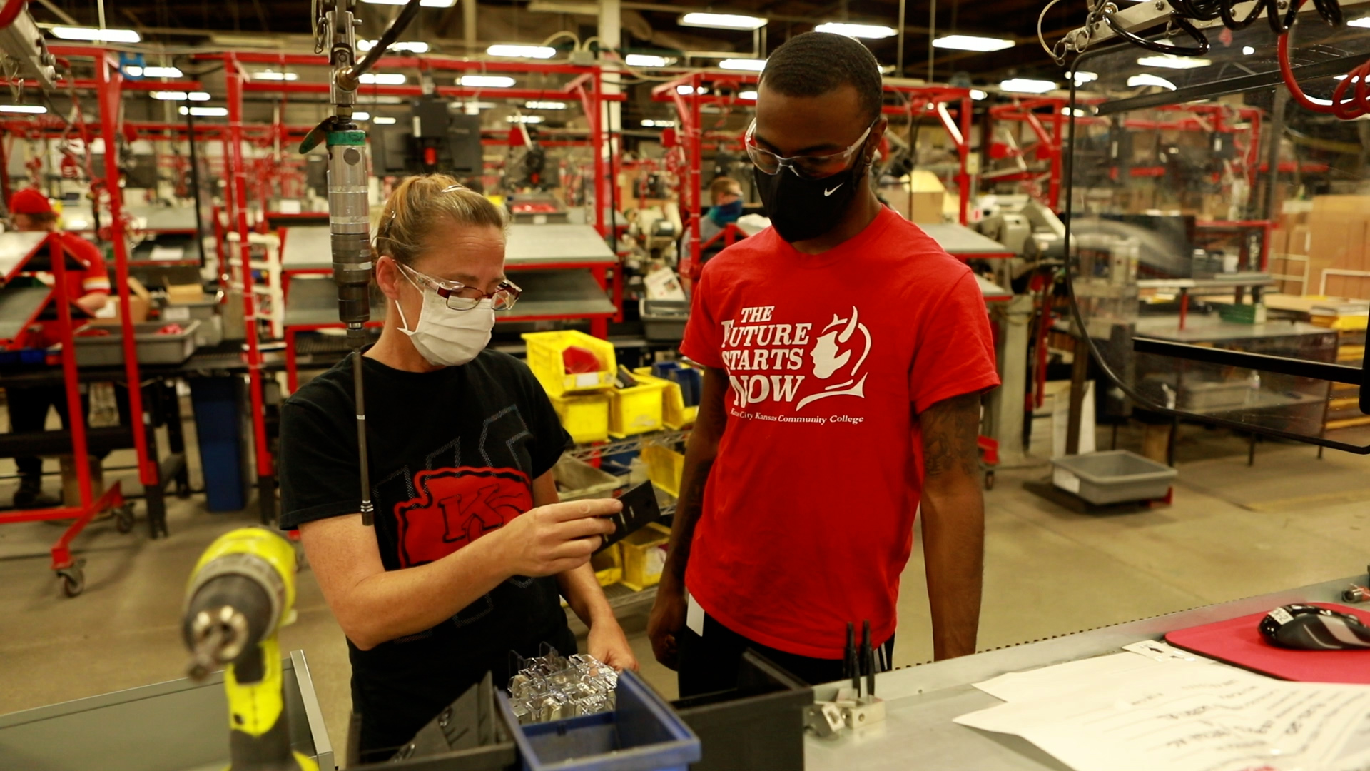 A Milbank training supervisor demonstrates part of the manufacturing process to another employee.